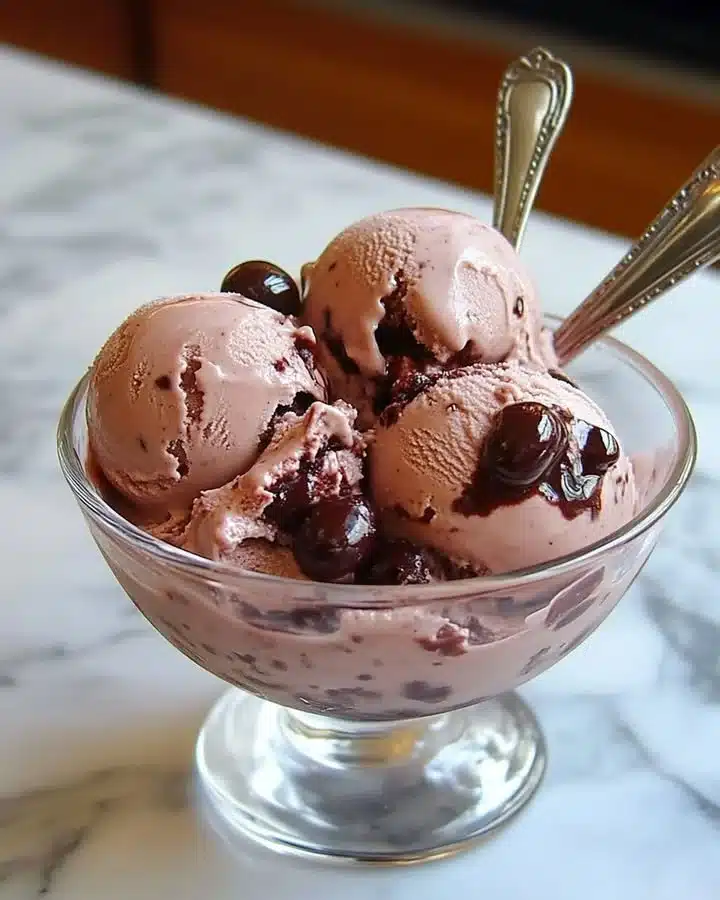 Bowl of creamy homemade cherry ice cream topped with fresh cherries
