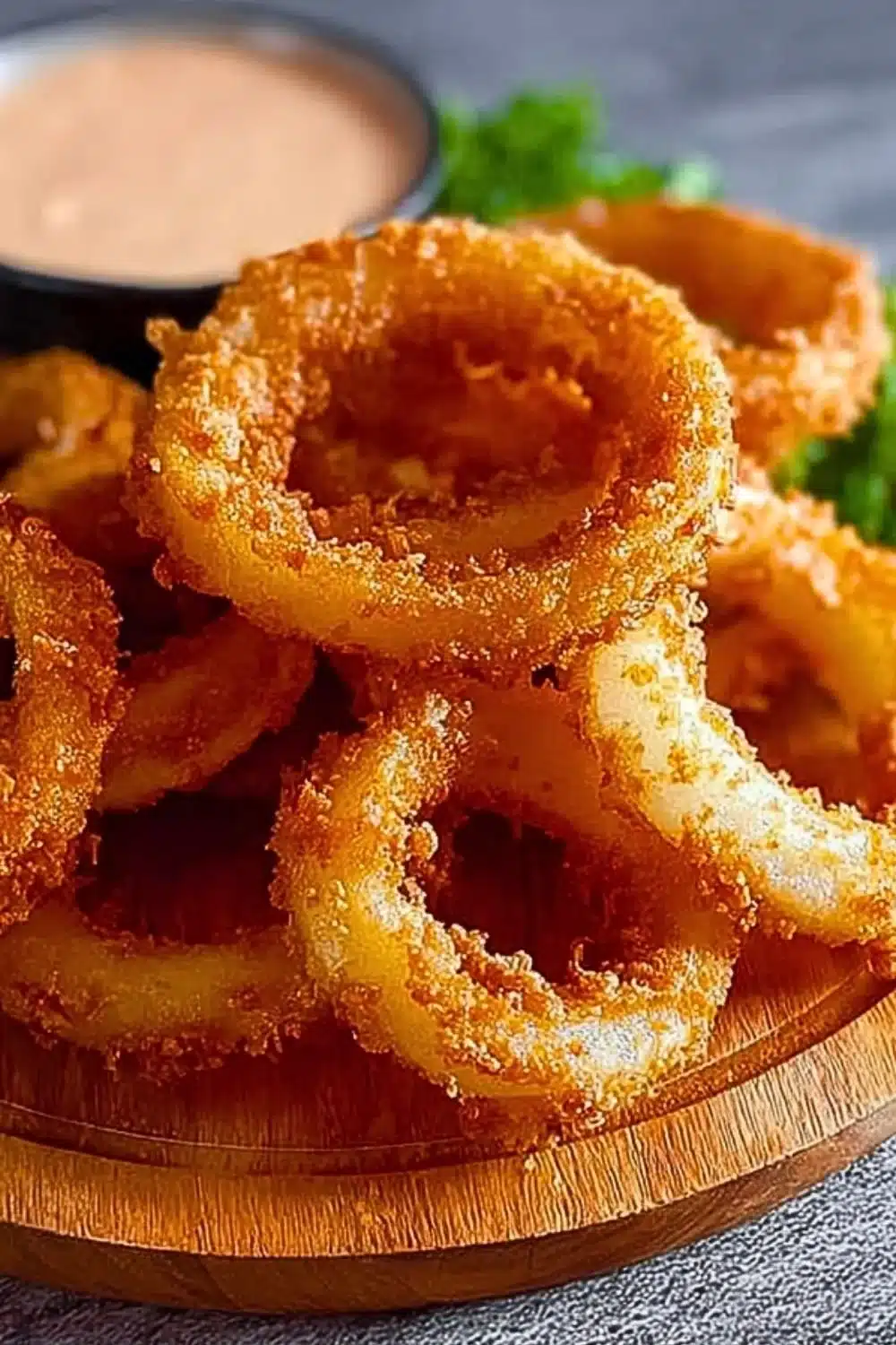 Homemade crispy onion rings served on a plate with dipping sauce