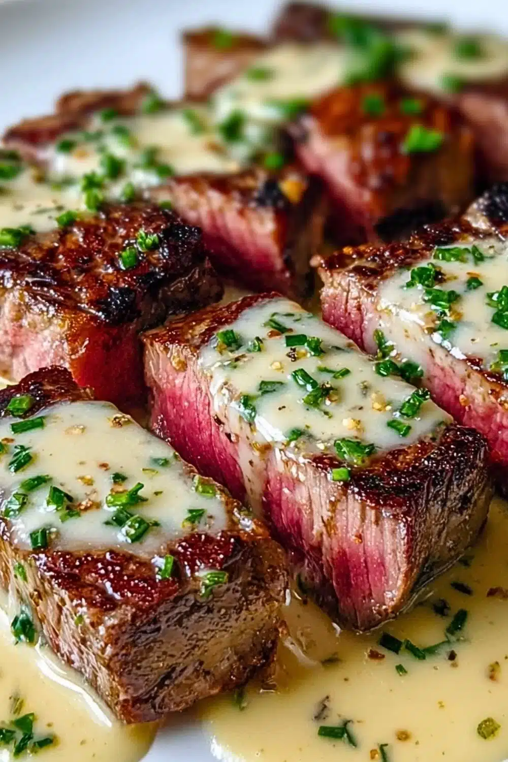 Delicious juicy steak topped with creamy garlic sauce on a plate