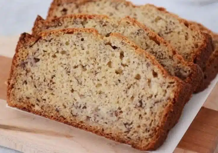 Slice of Paula Deen's banana bread with sour cream on a wooden table