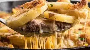 A delicious serving of Hobo Casserole with beef, potatoes, and vegetables in a baking dish.