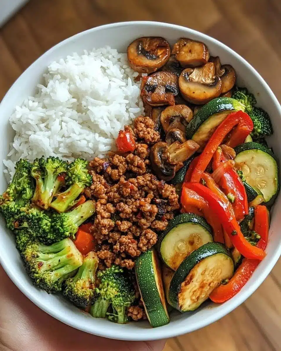 Spicy ground beef stir-fry bowl with garlic veggies and rice