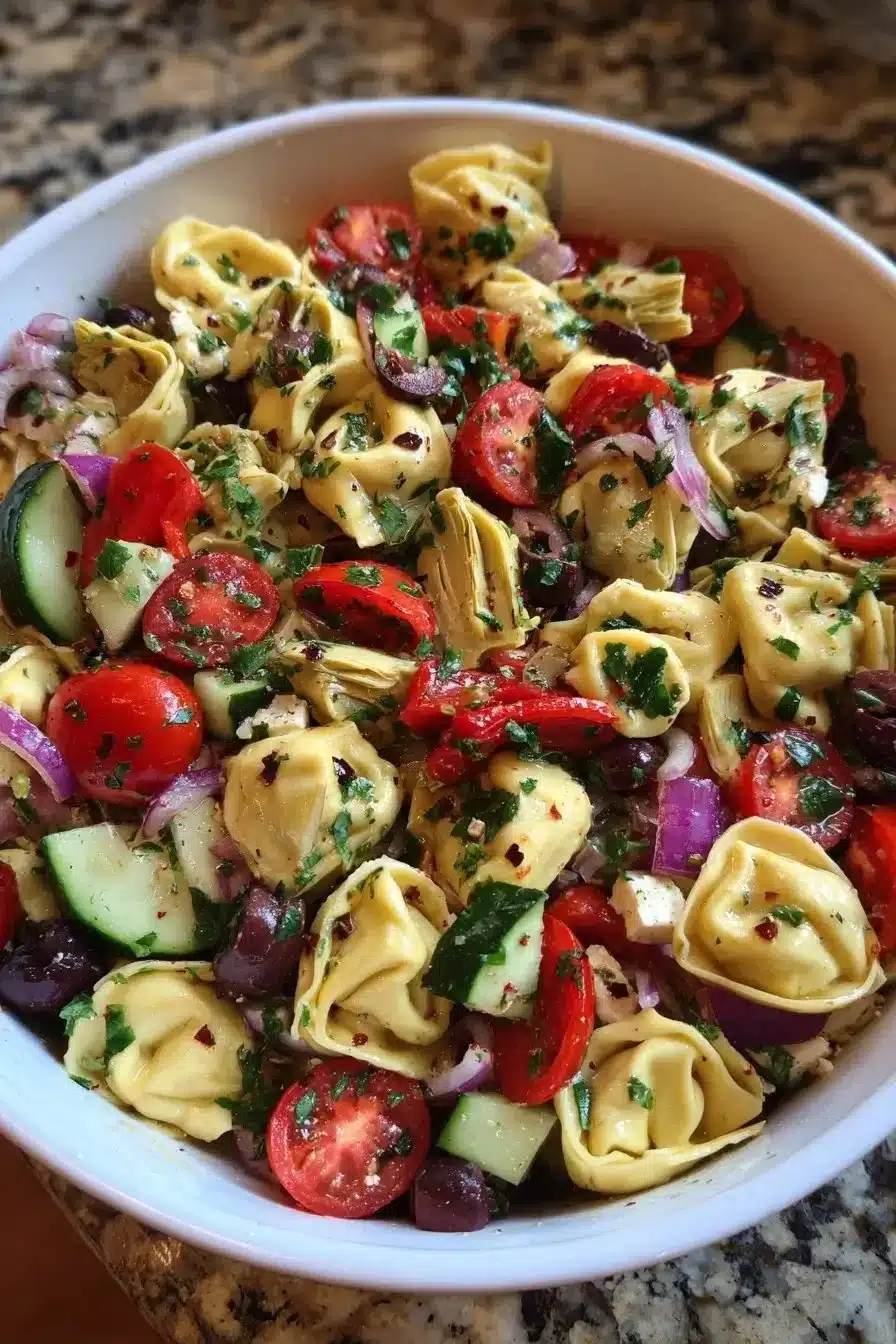 Mediterranean tortellini salad with artichokes and olives in a bowl