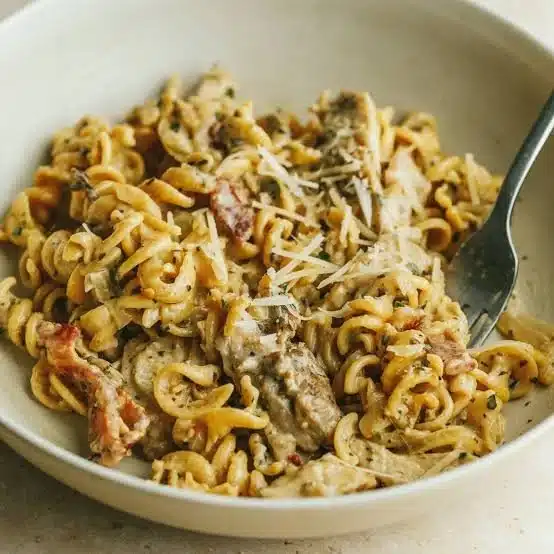 Creamy garlic chicken pasta dish garnished with fresh herbs