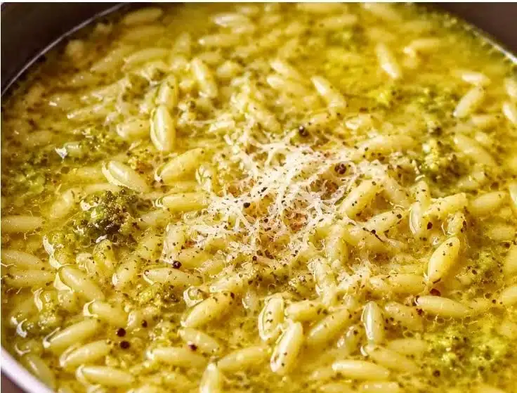 A bowl of Italian Broccoli Soup garnished with fresh herbs and bread.