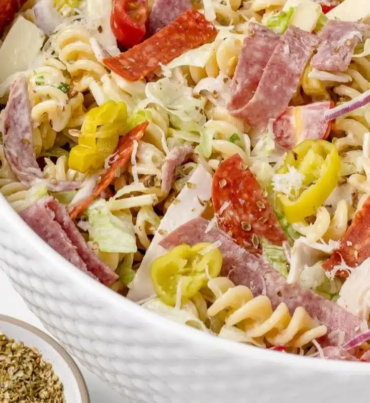 Delicious Italian Grinder Pasta Salad in a bowl with fresh ingredients and dressing.