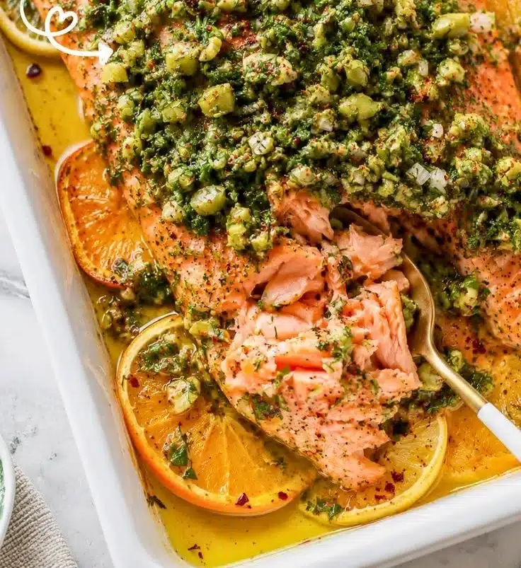 Olive-Citrus slow roasted salmon garnished with fresh herbs