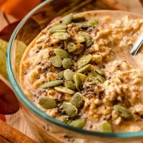Bowl of Pumpkin Protein Overnight Oats topped with nuts and seeds.
